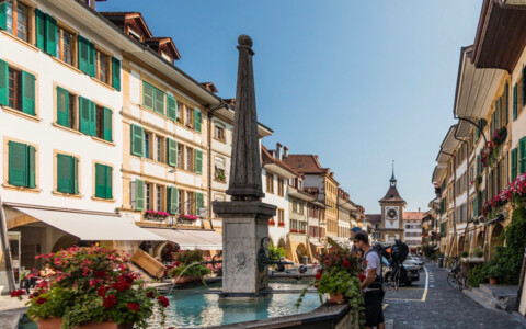 Senioren an einem Brunne in der Innenstadt von Murten - Tagesausflug an den Murtensee mit Born Reisen