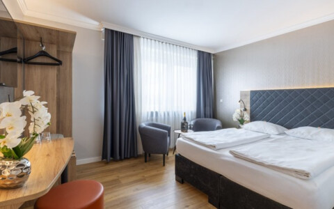 Modern eingerichtetes Hotelzimmer im PLAZA INN Rieker Stuttgart Hauptbahnhof mit Doppelbett, kostenlosem WLAN und Kabel-TV – ideal für Städtetrips und Geschäftsreisen.