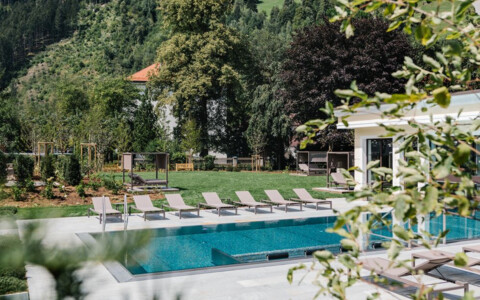 Beheizter Aussenpool im Sommergarten des Hotel Bräu mit Liegen und Bergblick