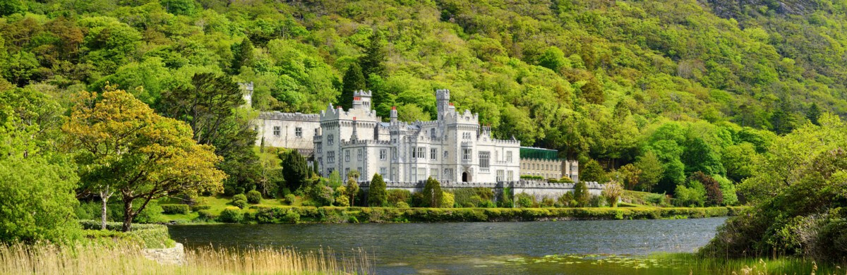 Kylemore Abbey inmitten der grünen Berg- und Seenlandschaft von Connemara im Westen Irlands.