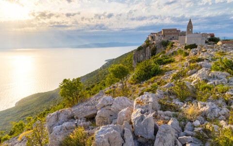 Sonnenuntergang über der Insel Cres in Kroatien mit Blick auf die Adria und alte Steinhäuser.