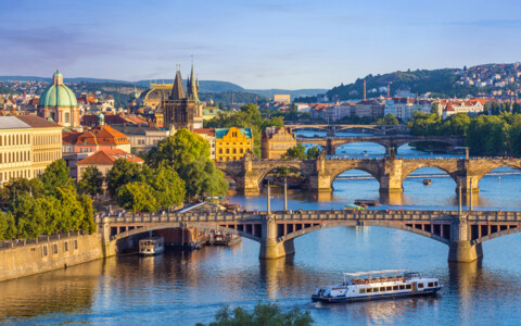 Blick über die Moldau auf die historische Altstadt von Prag mit ihren Brücken, Türmen und Kuppeln.