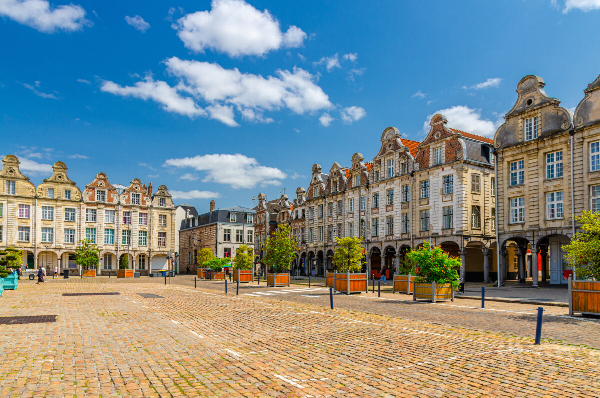 Historischer Grand’Place in Arras mit prächtigen Fassaden, Arkaden und Kopfsteinpflaster.