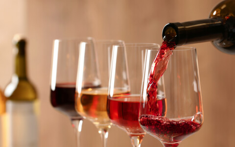 Weinverkostung: Eine Reihe von Weingläsern aufgereiht, bereit zur Verkostung verschiedener Weinsorten in einer gemütlichen Umgebung.