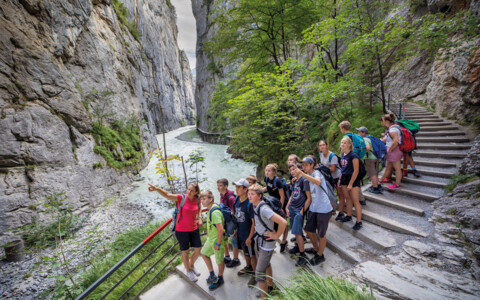 Besucher spazieren auf dem Wanderweg entlang der tosenden Aare in der Aareschlucht im Berner Oberland