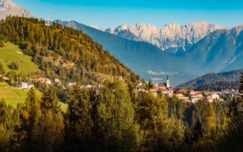 Blick auf Seefeld in Tirol mit herbstlicher Berglandschaft und den markanten Gipfeln der Alpen im Hintergrund. Arztal