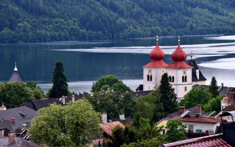 Blick auf Millstatt am Millstätter See mit Stiftskirche und Kärntner Berglandschaft.