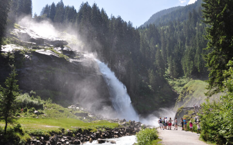 Besucher bestaunen die Krimmler Wasserfälle in Österreichs Alpenlandschaft.